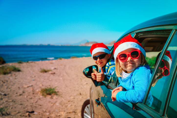 Children in a car wearing Santa hats
